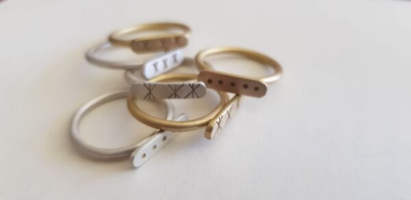 An array of brass and silver Stefni signet rings in different styles