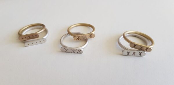 Paired brass and silver Stefni signet rings in different styles