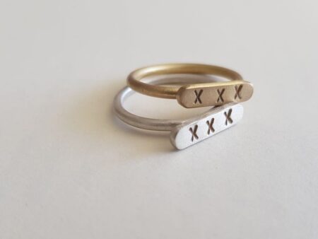 Brass and Silver Kiss signet rings as stack rings