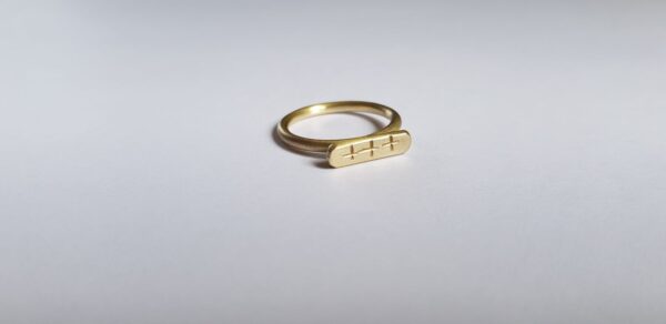 Side angle of brass crisscross signet ring