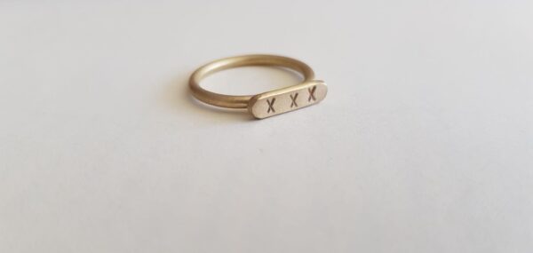 Brass round wire signet ring with letter punched kisses