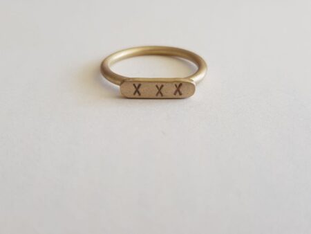 Brass round wire signet ring with letter punch kisses front view