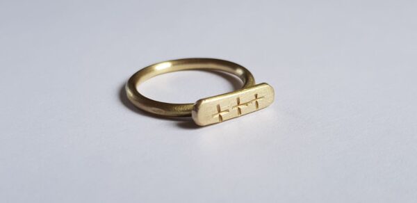 Close up of brass crisscross signet ring