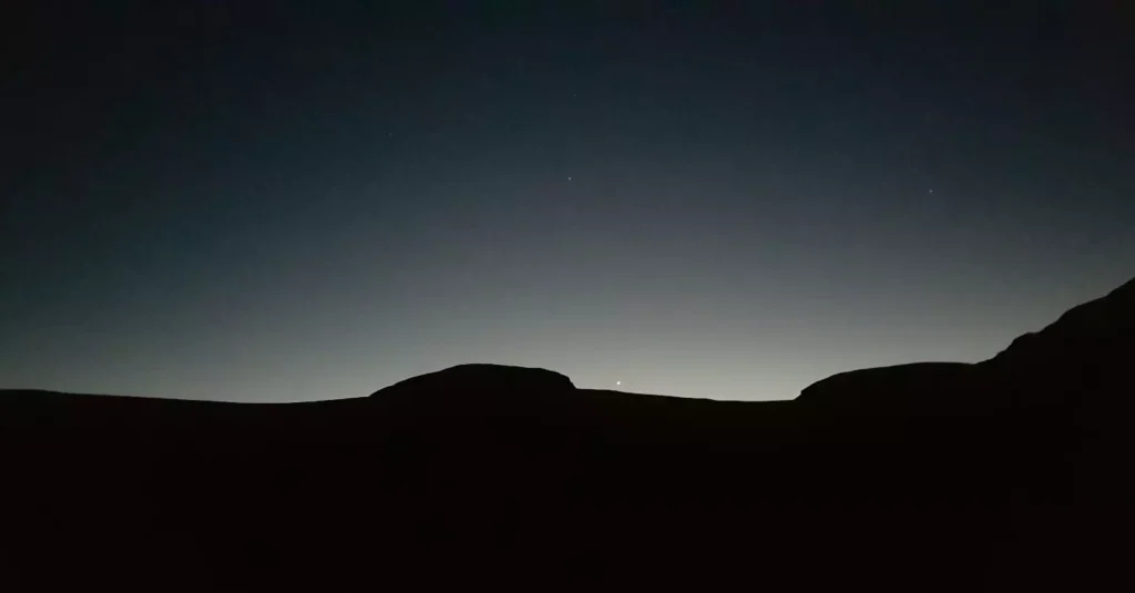 Dancing morning star over dawn lit mountains