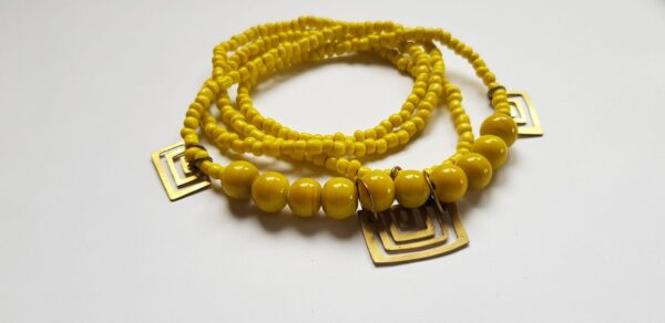 Yellow glass bead necklace with brass handmade brass cutouts side angle