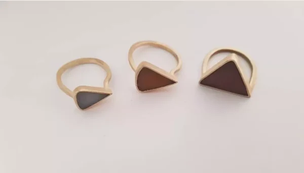 A set of triangle rings in mixed metal with washed up ocean debris as stone simulants