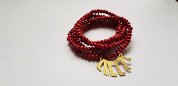 Right angle of red dyed wood bead necklace with brass Malawi kids drawn symbol
