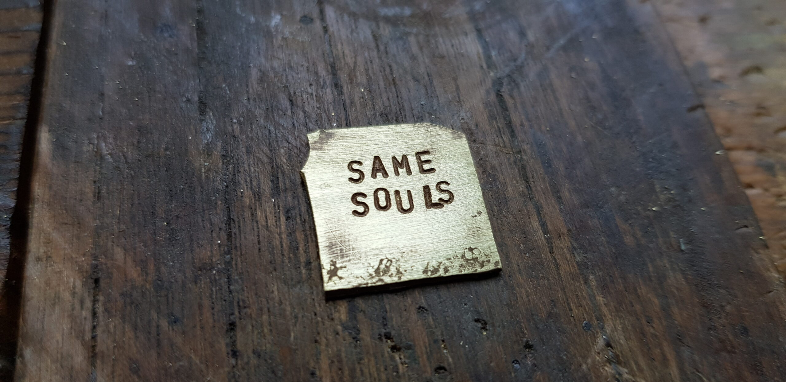 Letter stamped detail in brass on a jewellery bench