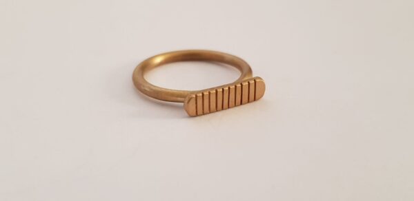 Close up of single brass striped signet ring by Stefni