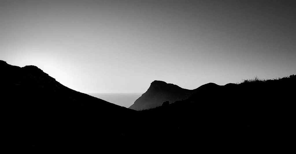 Sunrise over the Cape Point mountains in black and white