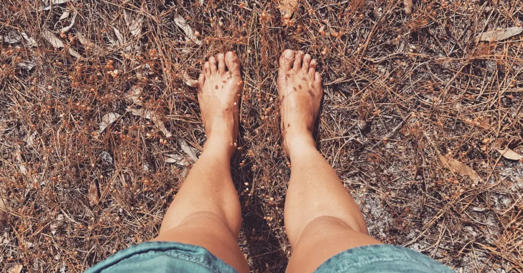 Bare feet firmly planted in the earth near the foot of the Cape Point mountains